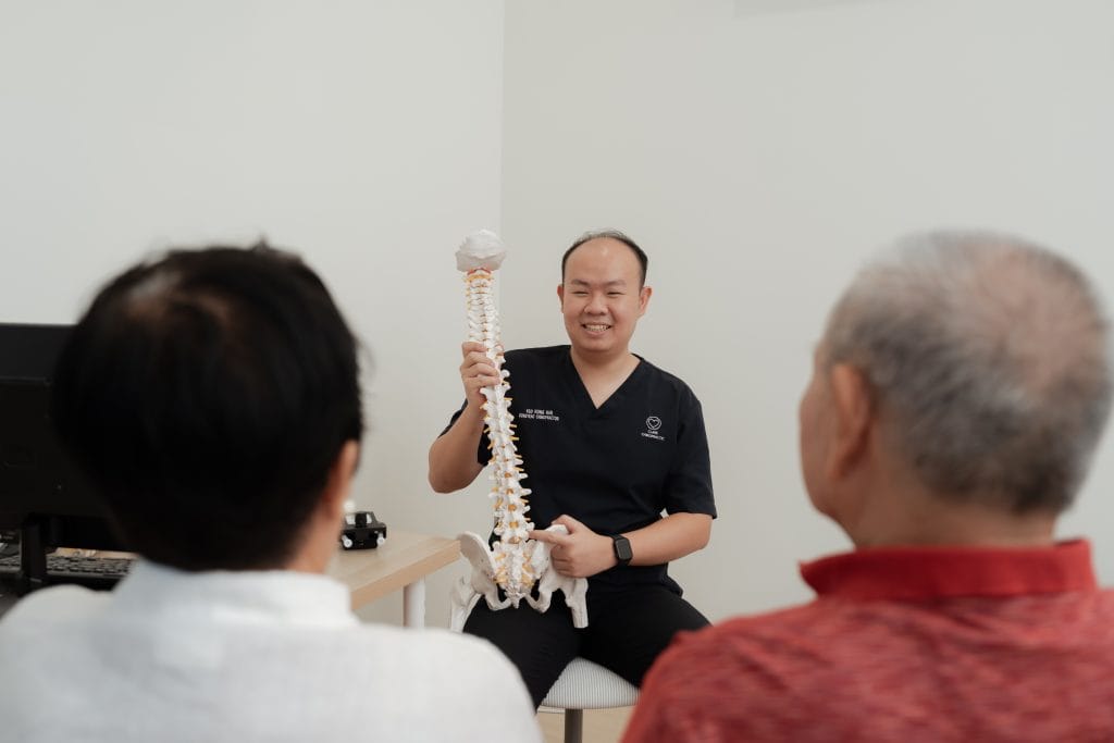 Rong Han is explaining spine health during a consultation