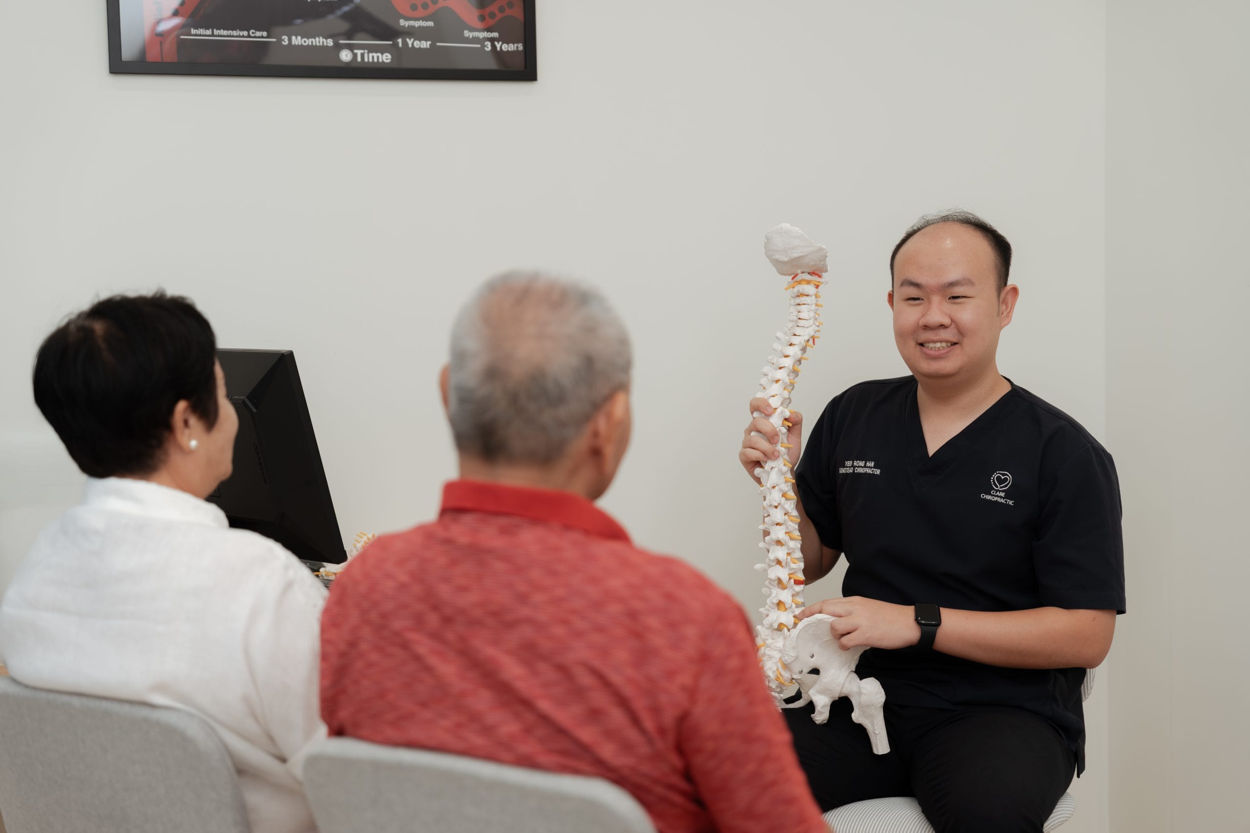 Rong Han is explaining spine health to a couple