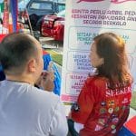 yeo doing a explanation on causes of back pain to a madam